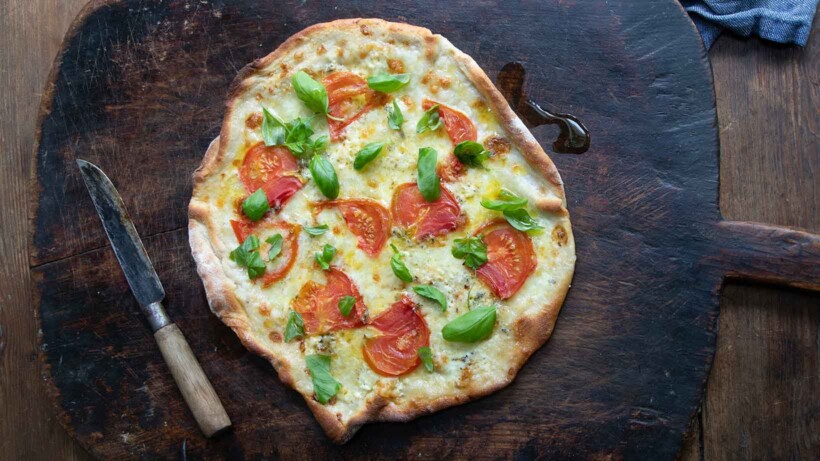 Pizza maken met mozzarella, blauwschimmelkaas en basilicum